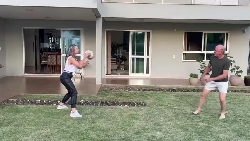 Janice orientando um treino ao ar livre em uma residência, fotografia real.